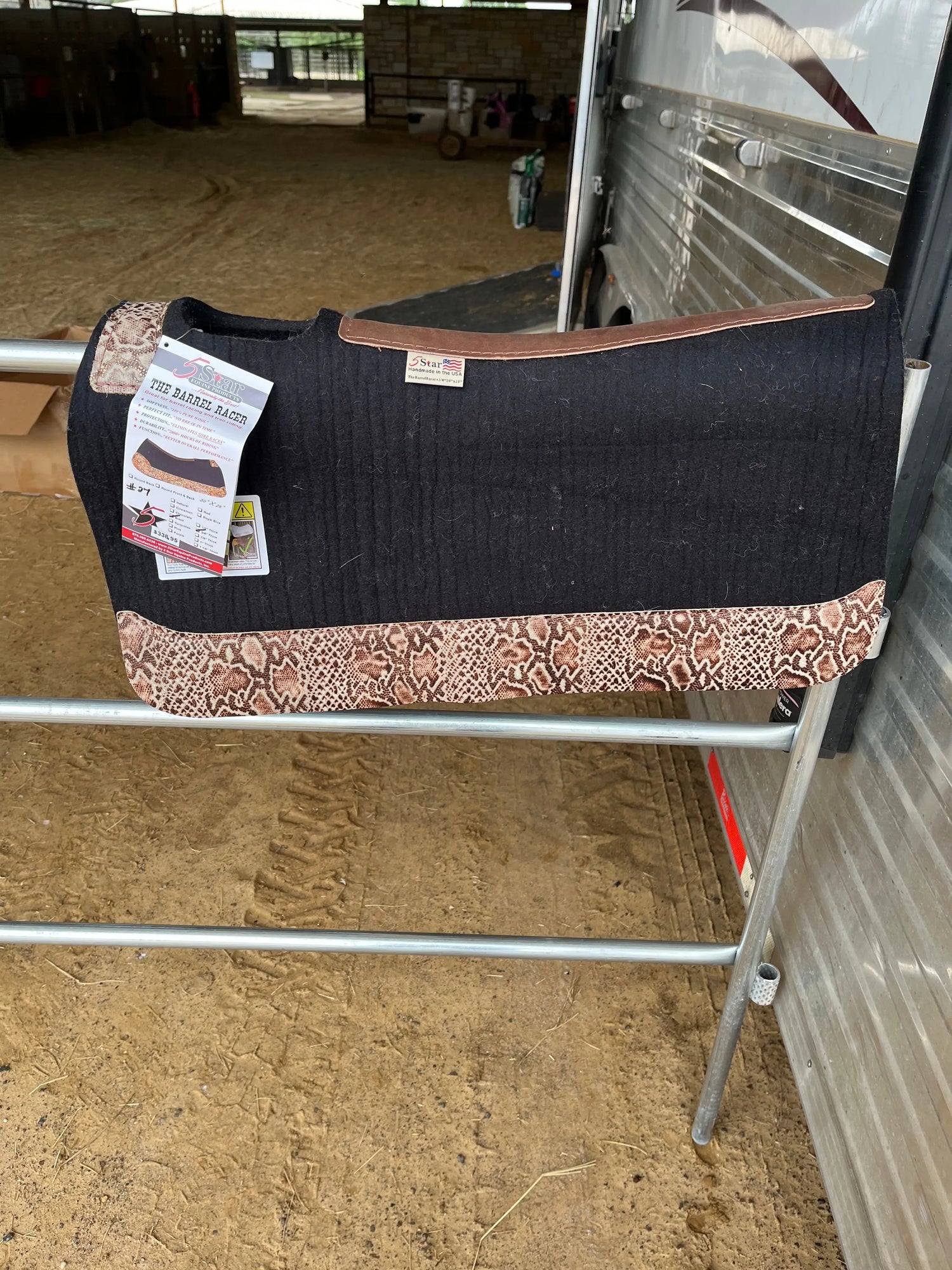 5-Star Saddle Pads displayed in a barn setting, showcasing a stylish black and snake print design, ideal for equestrian enthusiasts looking for high-quality saddle pads.