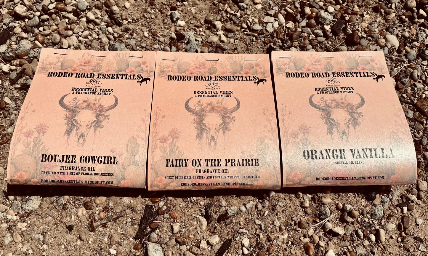 Rodeo Road Essentials Car or Trailer Sachet featuring three distinct scents: Boujee Cowgirl, Fairy on the Prairie, and Orange Vanilla, displayed against a rustic gravel background.