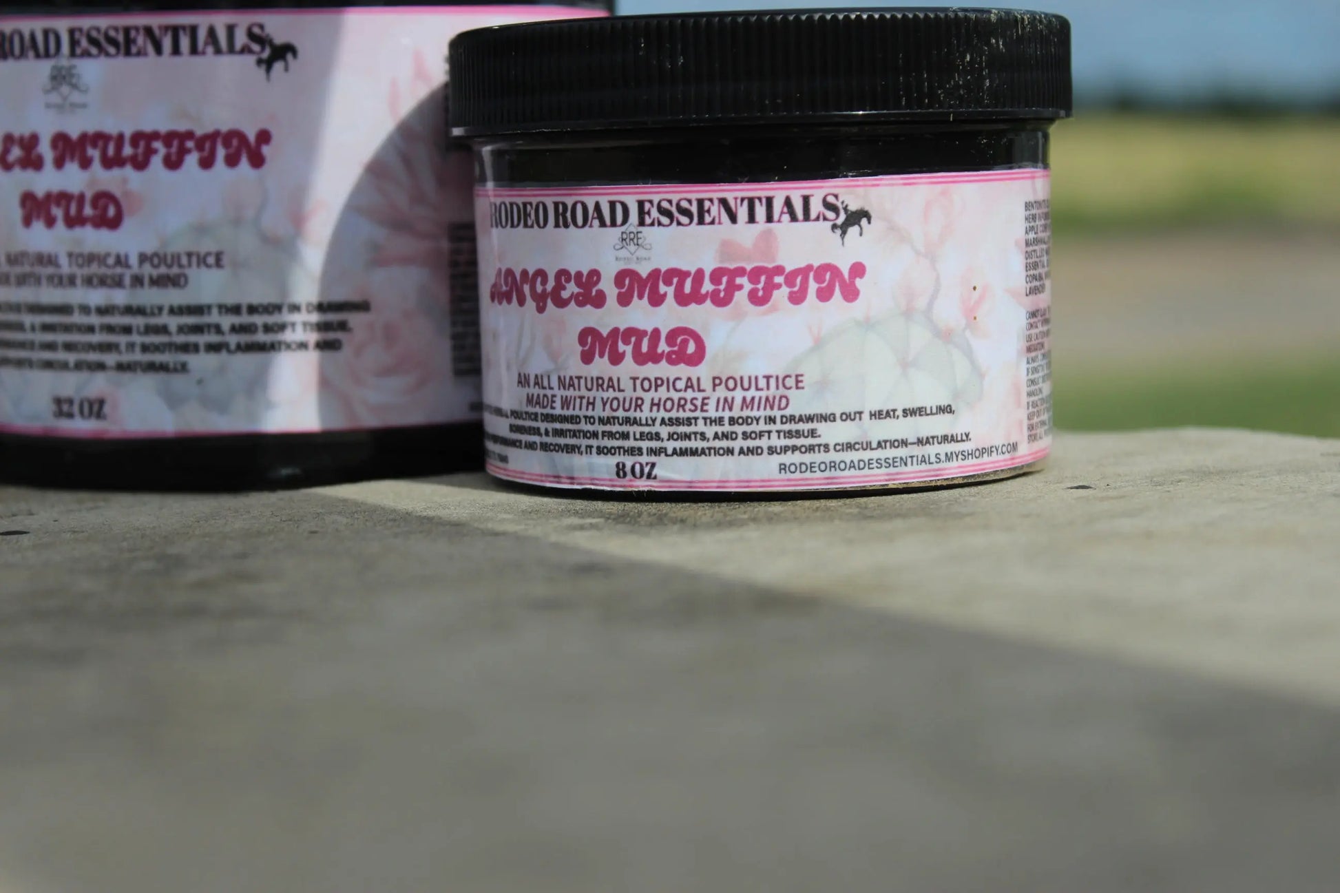 Angel Muffin Mud 8 oz jar placed outdoors, emphasizing natural recovery for sore legs and joints of horses.