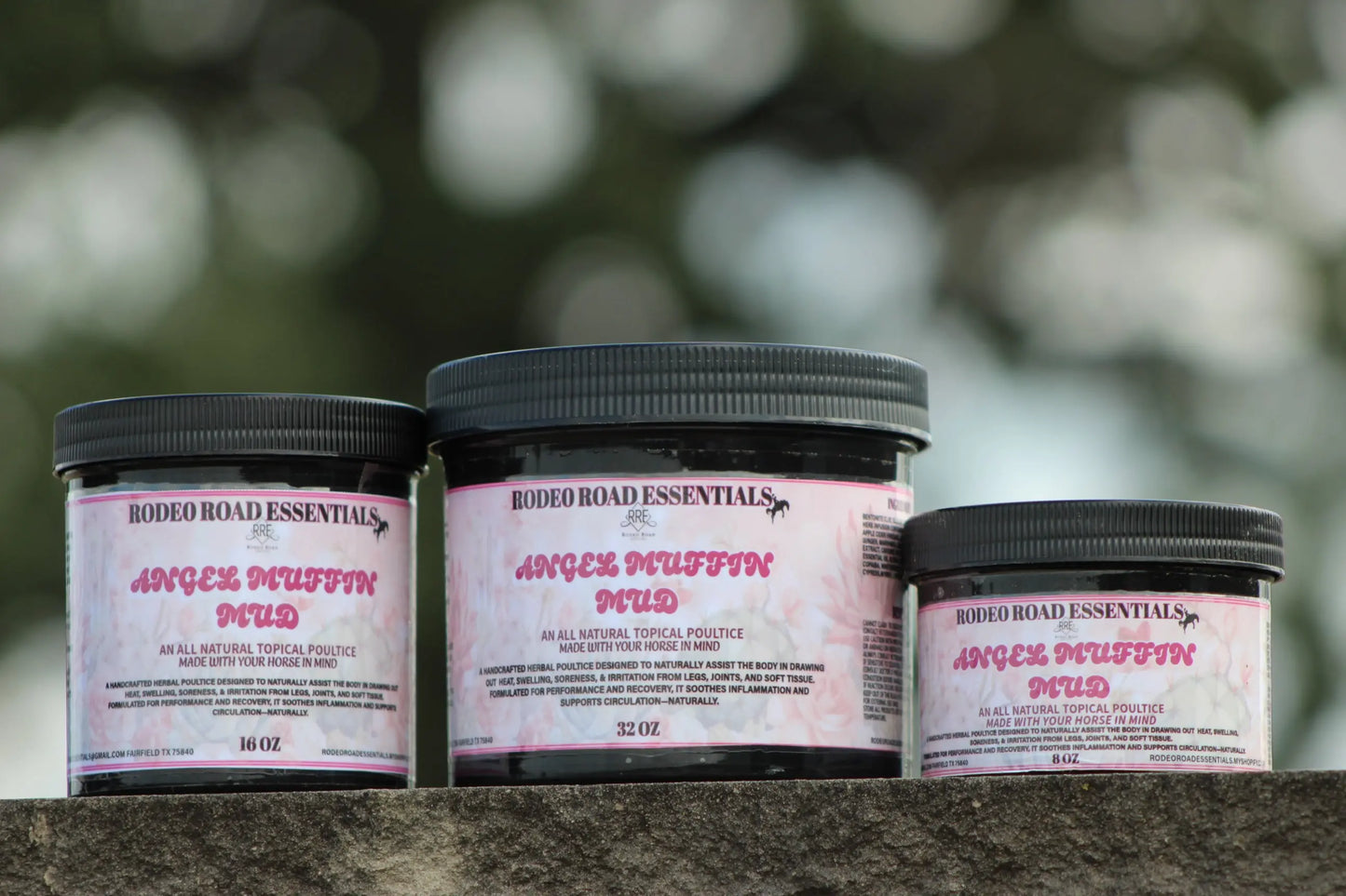 Angel Muffin Mud – All-natural topical poultice jars in various sizes displayed outdoors, ideal for recovery of sore legs and joints.