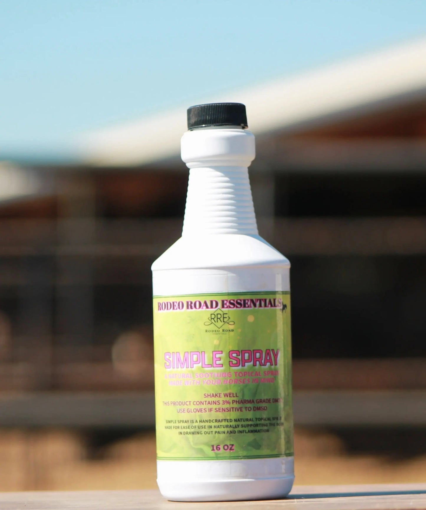 Rodeo Road Essentials Simple Spray 16 oz bottle displayed outdoors, representing the Everyday Herbal Comfort Spray for muscle support in horses.